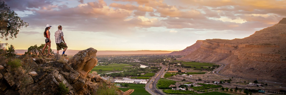 A couple taking in the scenery at the Rim Trail Overlooking the Grand Valley